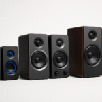 Różne modele głośników komputerowych różnych półek cenowych ustawione obok siebie na neutralnym tle