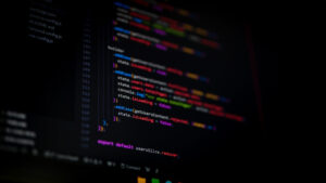 Tekst programistyczny na ciemnym tle z kolorowymi liniami kodu.